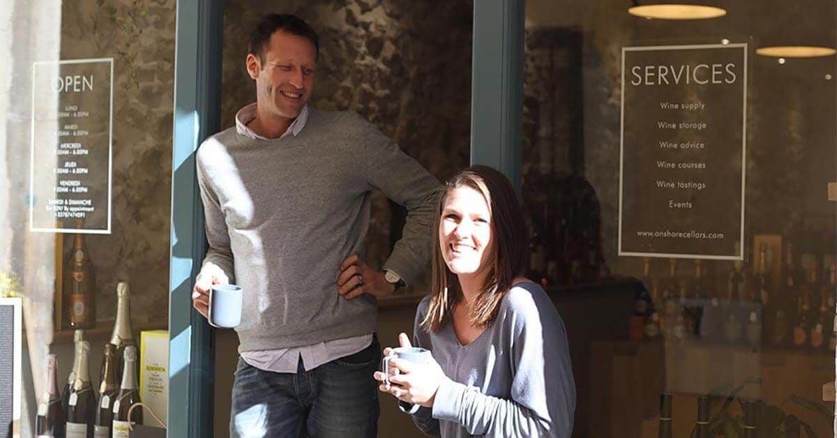 Ed and Jess Dunnett with mugs of coffee outside the Onshore Cellars shop